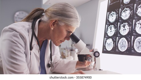 Mature white neurologist female looking at x-rays