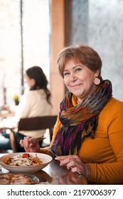 Mature Woman 60s Years Old Is Lunching With Coffee In Cafe.