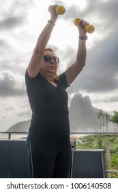 Mature Woman (70-79) Exercising With Dumbells At Public Gym In Ipanema, Rio De Janeiro, Brazil