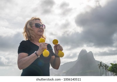 Mature Woman (70-79) Exercising With Dumbells At Public Gym In Ipanema, Rio De Janeiro, Brazil