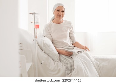 Mature woman after chemotherapy reading book in clinic - Powered by Shutterstock