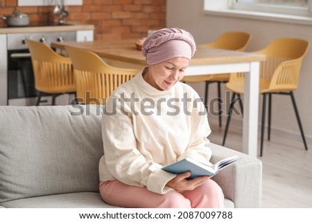 Mature woman after chemotherapy reading book at home