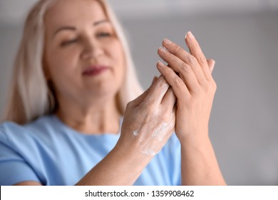 Mature Woman Applying Hand Cream At Home