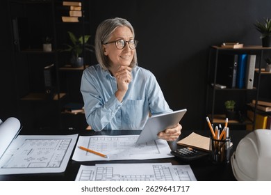 Mature woman, architect and blueprint with tablet, computer and design for vision or project. Female person, professional and technology as designer or creative for management, company or development