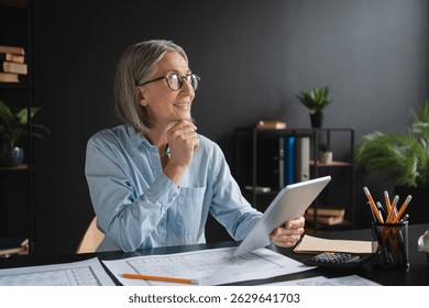Mature woman, architect and thinking with tablet, blueprint or design for project in office. Female person, professional and technology as designer or creative in management, company or development