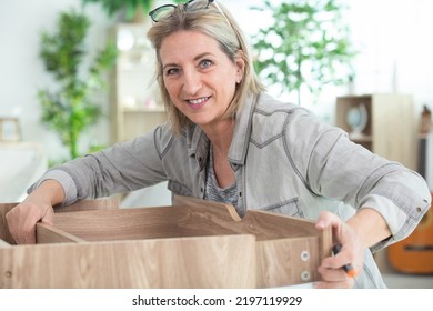 Mature Woman Assembling Furniture At Home