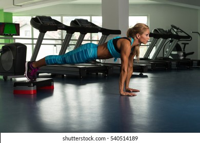 Mature Woman Athlete Doing Pushups On Stepper As Part Of Bodybuilding Training