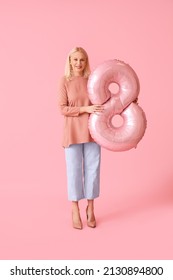 Mature Woman With Big Balloon In Shape Of Figure 8 On Pink Background. International Women's Day