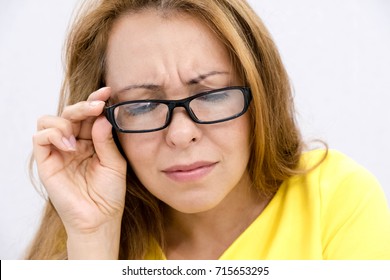 mature woman with black eye glasses trying to read book, having difficulties seeing text because vision problems. facial expression feelings reaction, look down, trying to share the information below