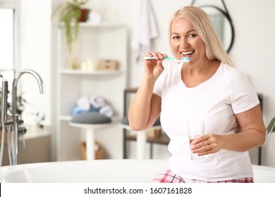 Mature Woman Brushing Teeth At Home