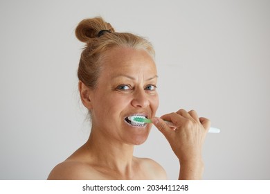 Mature Woman Brushing Teeth With Toothbrush As Healthy Morning Routine