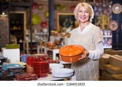 Mature Woman Buying Ceramic Cookware In The Shop