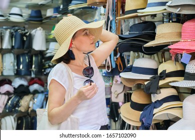 Mature Woman Buying Sun Hat In Street Store, Summer Vacation Shopping