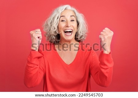 Mature woman celebrating while raising the fists