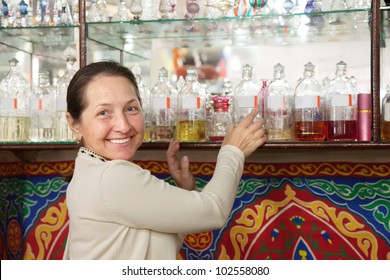 Mature Woman Chooses Essential Oils At  Shop