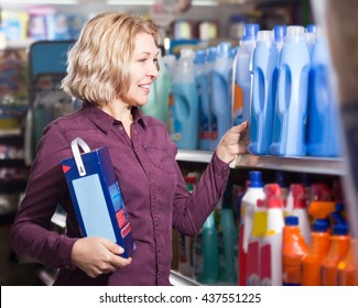 Mature Woman Choosing Detergent In Laundry Section