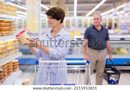 mature woman choosing sauerkraut cabbage and pickles