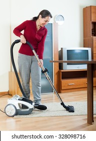 Mature woman cleaning living room