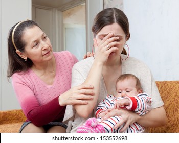 Mature Woman Comforts Crying Adult Daughter With Baby At Home