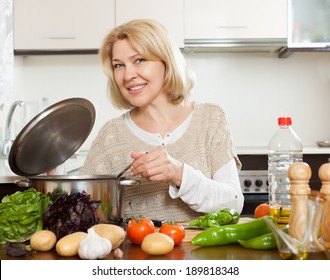 Mature Woman Cooking  Soup In Kitchen