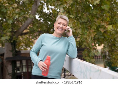 Mature Woman Cooling Down After Jogging And Talking On The Phone