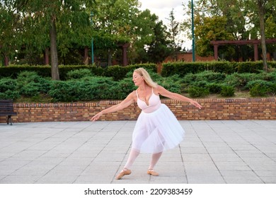 Mature Woman Dancing Ballet In A Park At Street.