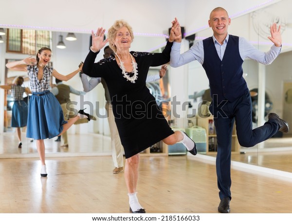 Mature woman dancing\
swing with young man