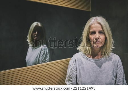 Mature woman, depression or mental health by bathroom mirror of house, home or hotel. Portrait, stress or anxiety of schizophrenia patient in psychology asylum with imposter syndrome, bipolar or fear