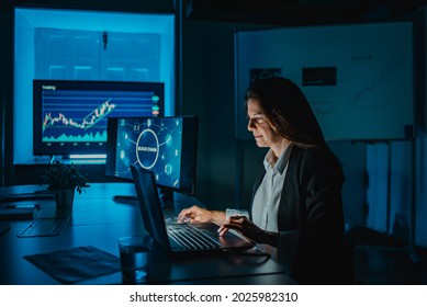 Mature Woman Doing Blockchain Research At Night Inside Bank Office - Focus On Face