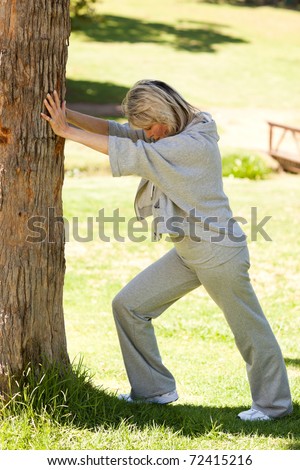 Mature woman doing her streches in the park