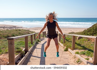 Mature Woman Doing Jumping Jacks With A Jumping Rope