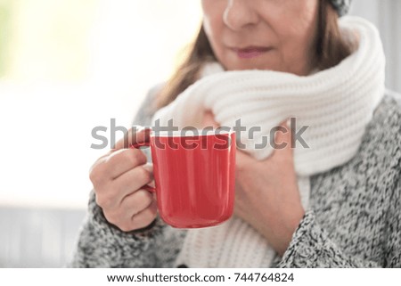 Mature woman drinking hot beverage in winter