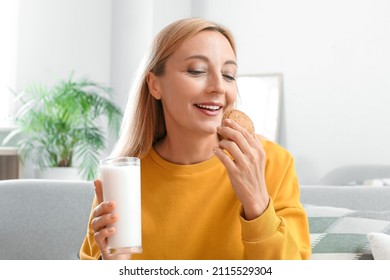 Mature Woman Drinking Milk And Eating Cookie At Home