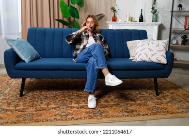 Mature Woman Drinking Red Wine Sitting On Sofa