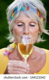 Mature Woman Drinking White Wine With Closed Eyes