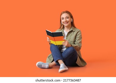 Mature Woman With Earphones And Book On Orange Background. Concept Of Studying German Language