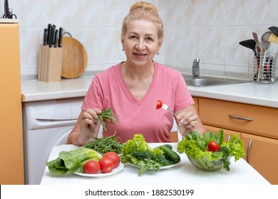 Mature Woman Eating Diet Vegetable Salad While Sitting At Home In The Kitchen. Healthy Meals