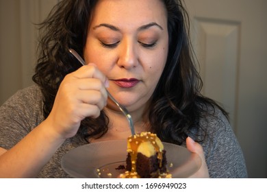 Mature Woman Eating A Piece Of Sweet Chocolate Cake In Kitchen