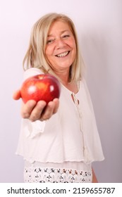 Mature Woman Eating A Red Apple , On A White Background.