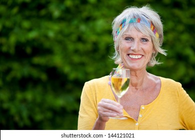 Mature Woman Enjoying A Glass Of White Wine