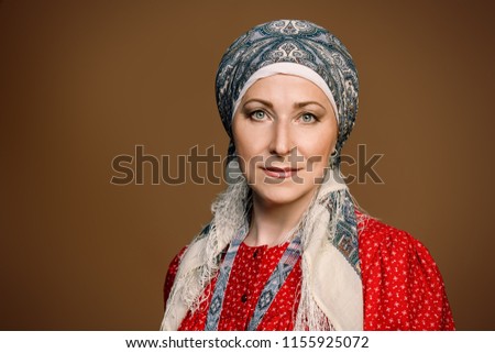 Mature woman in ethnic costume posing in studio.