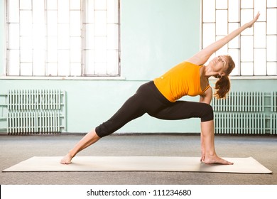 Mature Woman Exercising Yoga In A Gym