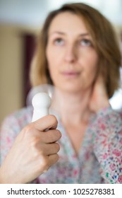 Mature Woman Experiencing Hot Flush From Menopause Using Electric Fan