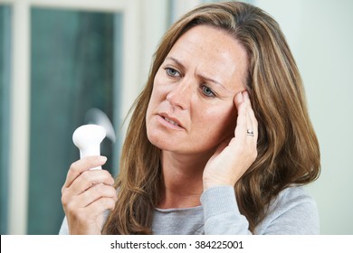 Mature Woman Experiencing Hot Flush From Menopause - Shutterstock ID 384225001