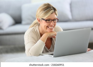 Mature Woman With Eyeglasses Websurfing On Laptop