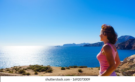 Mature Woman With Eyes Closed Relaxing On Sea Coast, Enjoy Breeze And Sunlight. Summer Holidays.