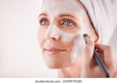 Mature woman, face mask with brush for smile in studio for skincare or anti aging on self care, wellness and fresh skin. Closeup, female person and glow with happiness for facial and beauty or luxury - Powered by Shutterstock