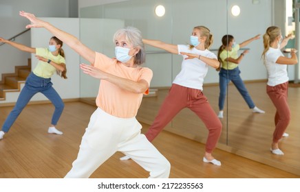 Mature Woman In Face Mask Dancing With Other Women During Group Class In Dance Center