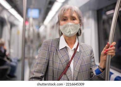 Mature Woman In Face Mask Standing Inside Subway Train And Waiting For Next Stop.