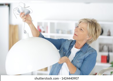 Mature Woman Fitting New Lamp Shade